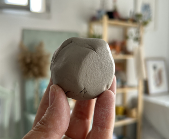 Manos sosteniendo una bola de barro al inicio de un curso de iniciación a la cerámica en Agalma Ceramics, Monachil, Granada.