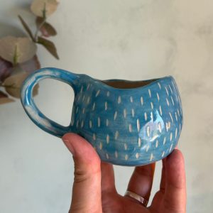 Taza mediana de cerámica azul turquesa decorada con esgrafiado