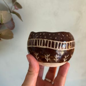 Tazón marrón de cerámica hecho a mano con decoración esgrafiada
