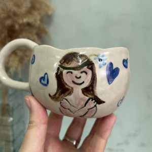 Taza de cerámica artesanal ilustrada a mano con una mujer y corazones