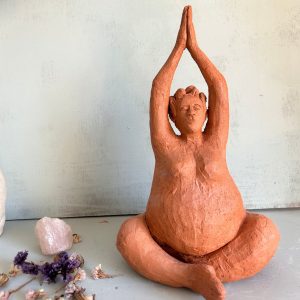 Escultura artesanal para la abundancia en postura de meditación