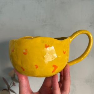 Taza grande de cerámica artesanal amarilla con corazones naranjas pintados a mano