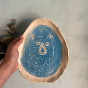 Plato de cerámica artesanal con osito esgrafiado sobre azul turquesa hecho por agalma ceramics