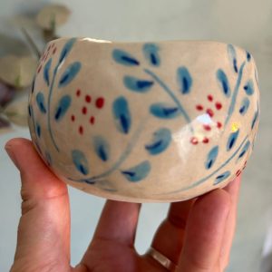 Tazón mediano beige de cerámica artesanal con ramas azules y frutos rojos